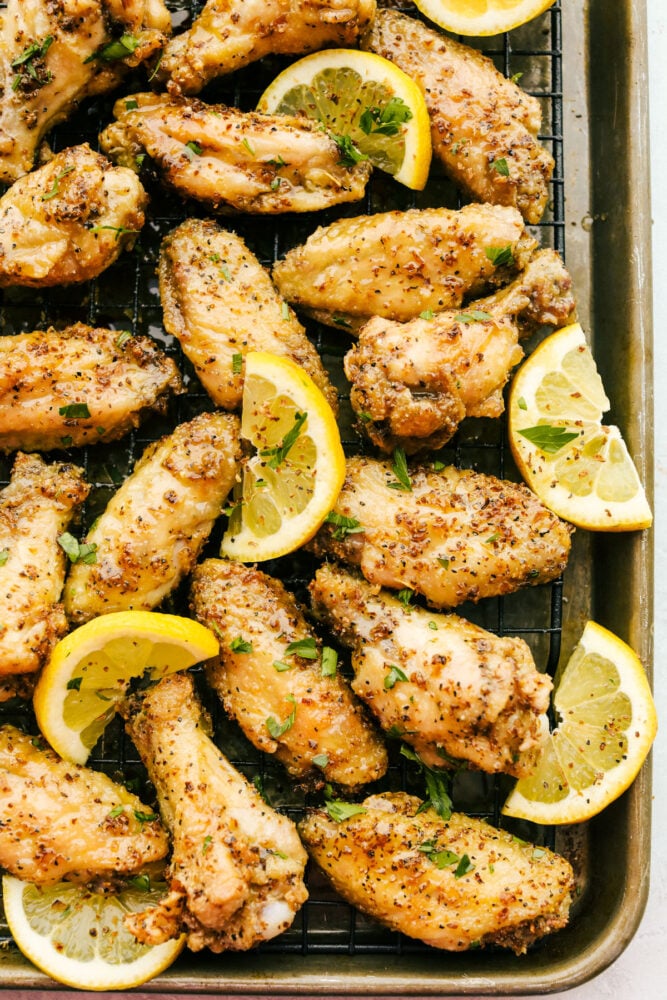 Lemon pepper wings on a wire rack with lemon garnish