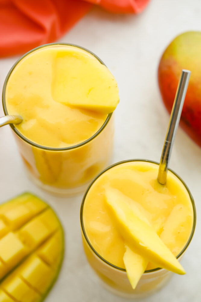 Top of view of a thick creamy smoothie garnished with fresh mango. 