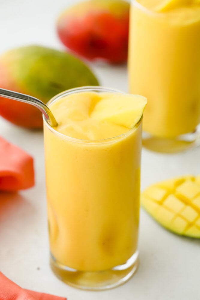 Mango smoothie in a glass with a straw. 