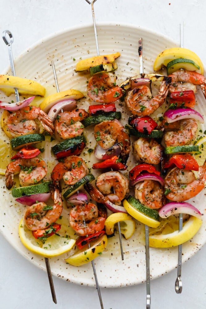 Shrimp and vegetable skewers grilled and on a plate ready to eat. 