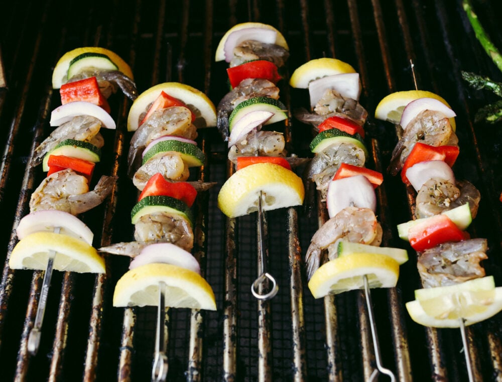 Shrimp Kabobs are marinated and grilled to perfection for the most scrumptious summer meal. Full of zesty flavors the whole family is going to love these kabobs! Shrimp kabobs on the grill.