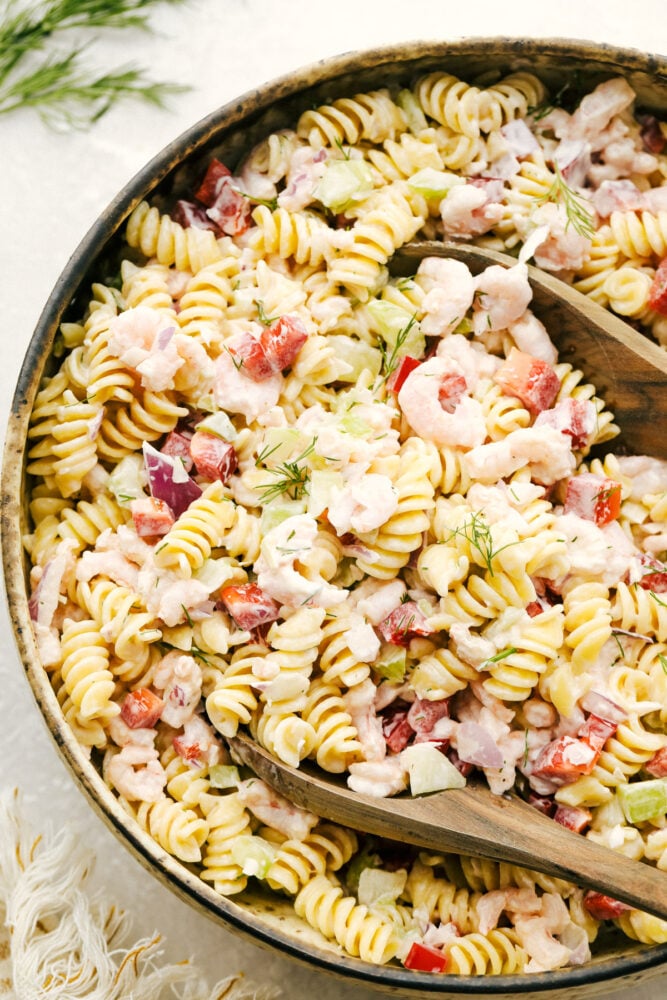 Shrimp pasta salad being mixed in a bowl