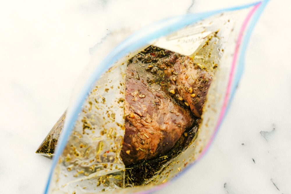 Skirt Steak Marinade is the perfect combination of spices and sauces to create a flavor that really pops! This incredible marinade works for more than just skirt steak too! Skirt steak in the marinade in a ziplock bag.