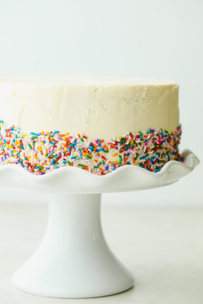 Frosted white cake with sprinkles added.
