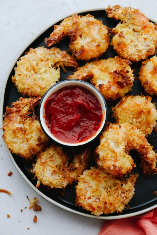 Air fried shrimp on a platter with some dipping sauce. 