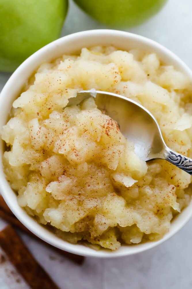 Finished homemade applesauce with spoon, ready to eat.