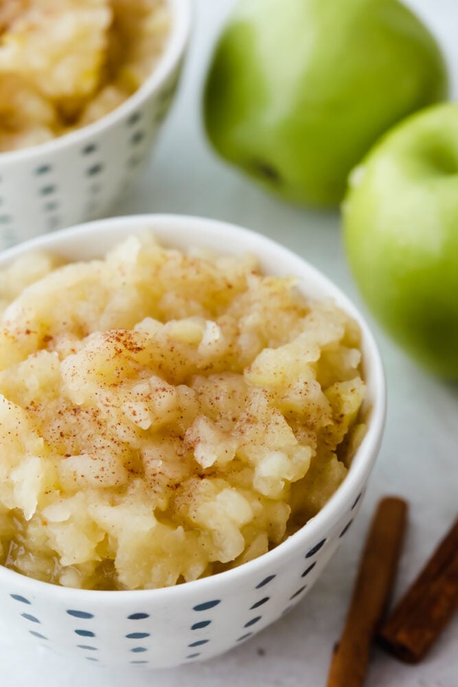 Applesauce in a bowl topped with cinnamon. 