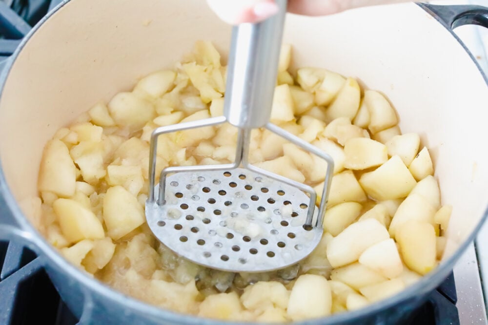 Cooked apples being mashed up. 