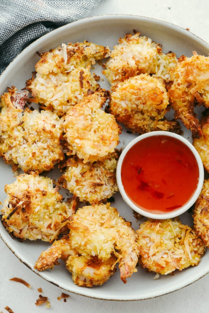 Baked Coconut Shrimp on a dish with serving sauce. 