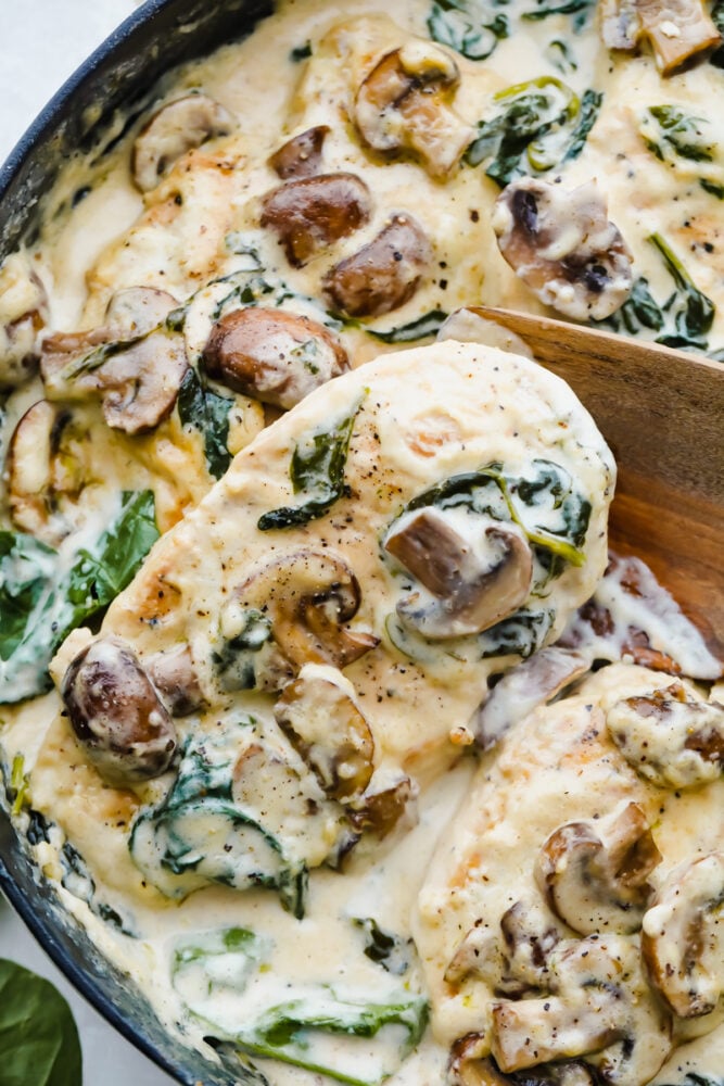 Chicken with mushrooms, parmesan cheese and garlic cooked in a skillet. 