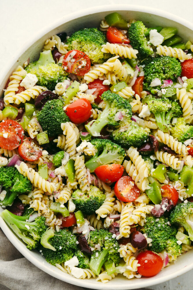 Greek broccoli pasta salad in a white bowl.