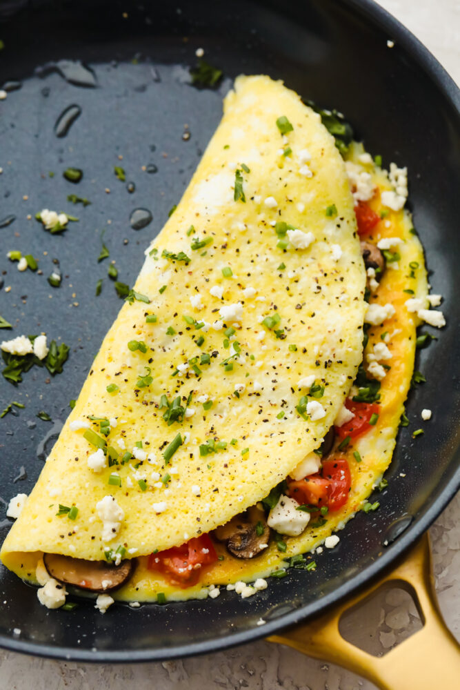 Omelette cooked with toppings in a frying pan. 