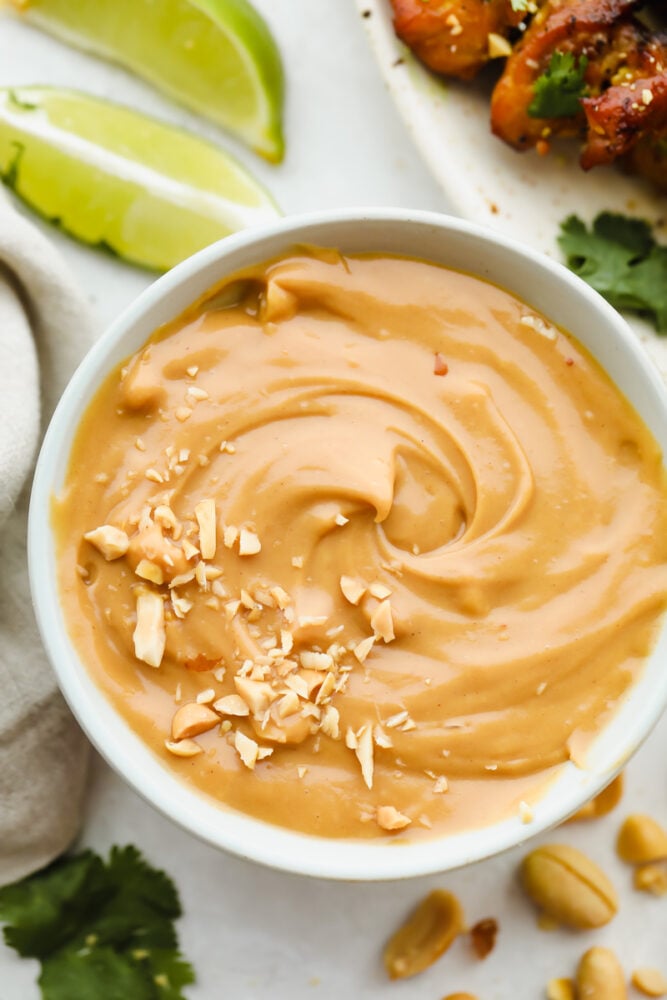 Bowl of peanut sauce with peanut garnish.