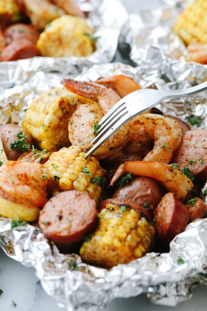 Taking a bite of corn in a Shrimp Boil Foil Packet.