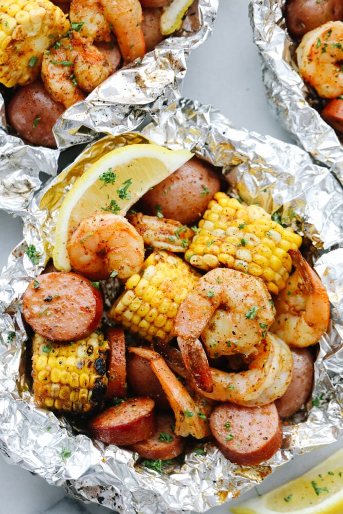 Cooked shrimp, sausage, and corn in a tin foil packet.