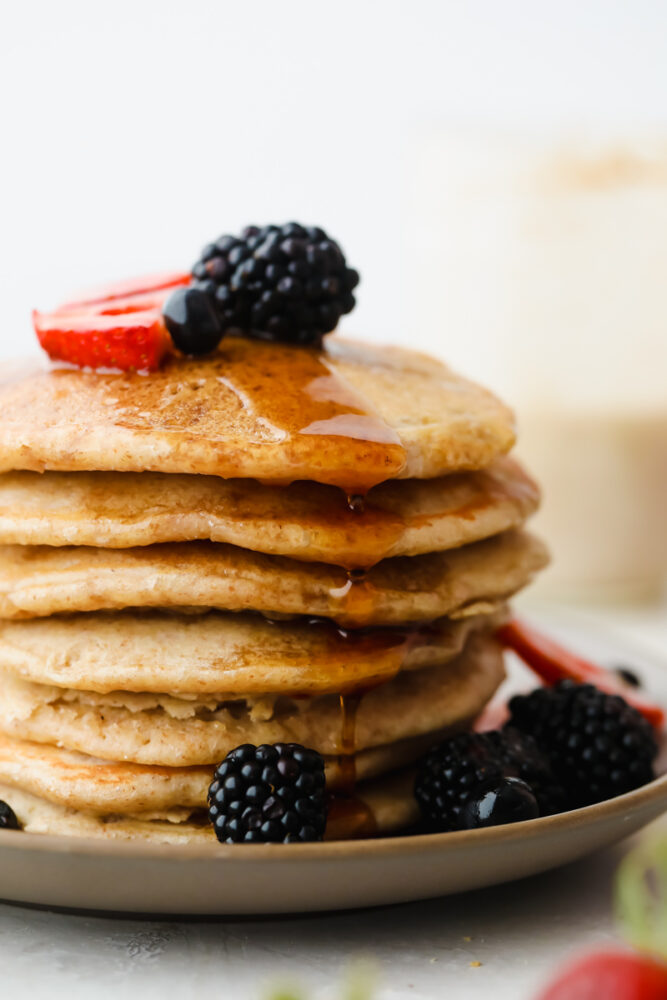 A stack of sourdough pancakes with berries on top. 