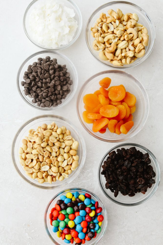 Ingredients for trail mix including peanuts, cashews raisins and dried apricots. 