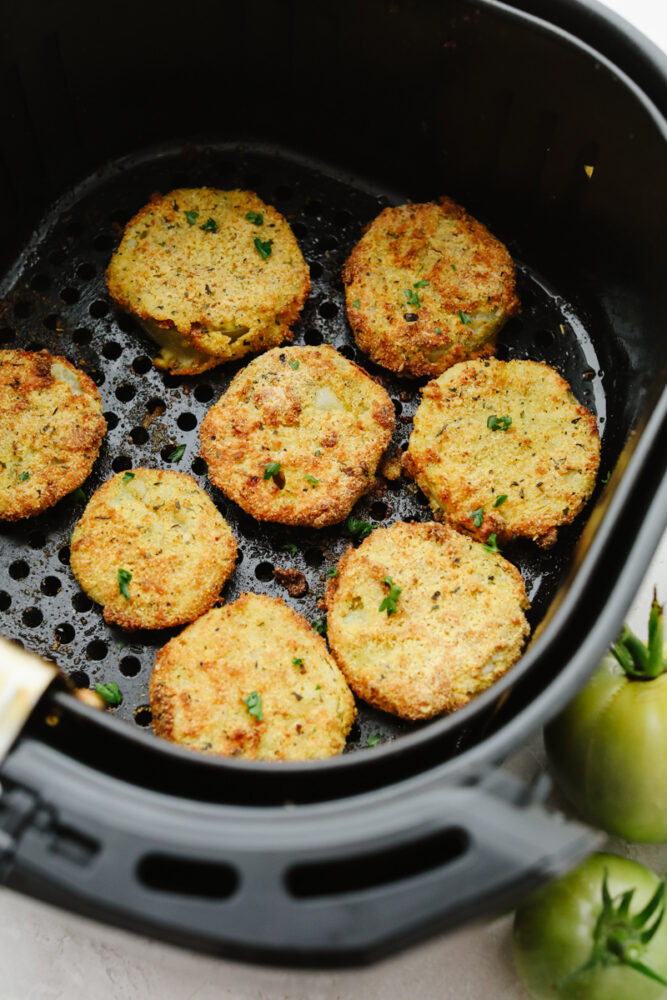 Green tomatoes frying in an air fryer. 