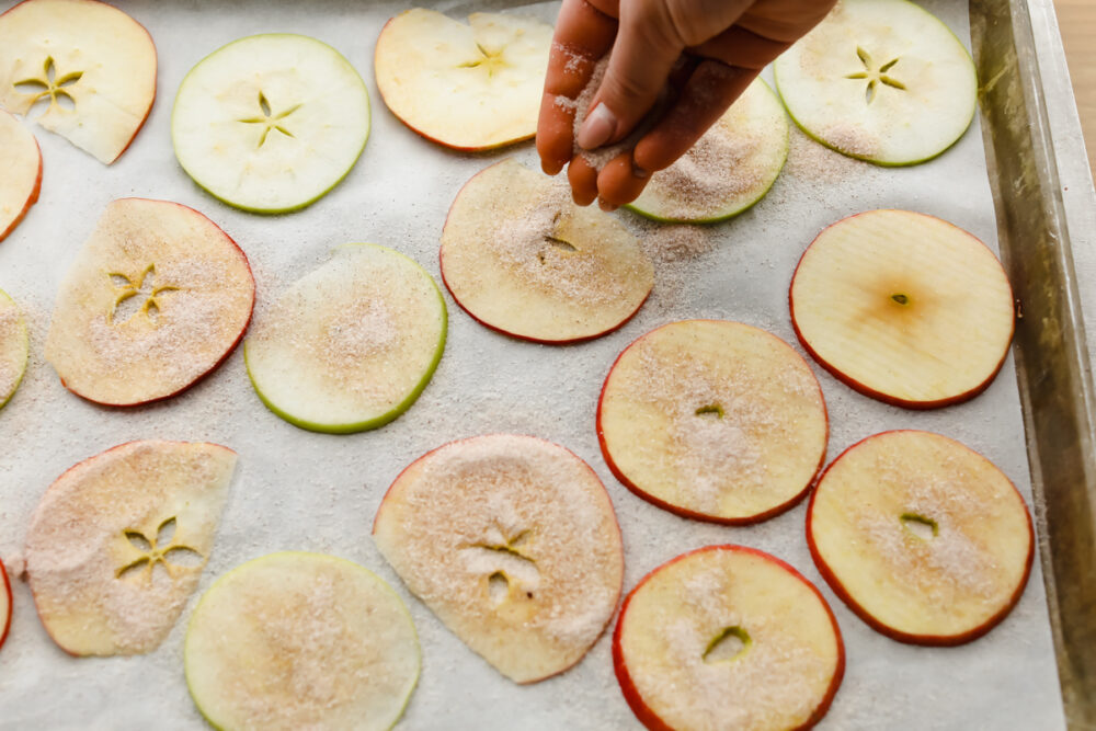 Sprinkling apple slices with cinnamon and sugar. 