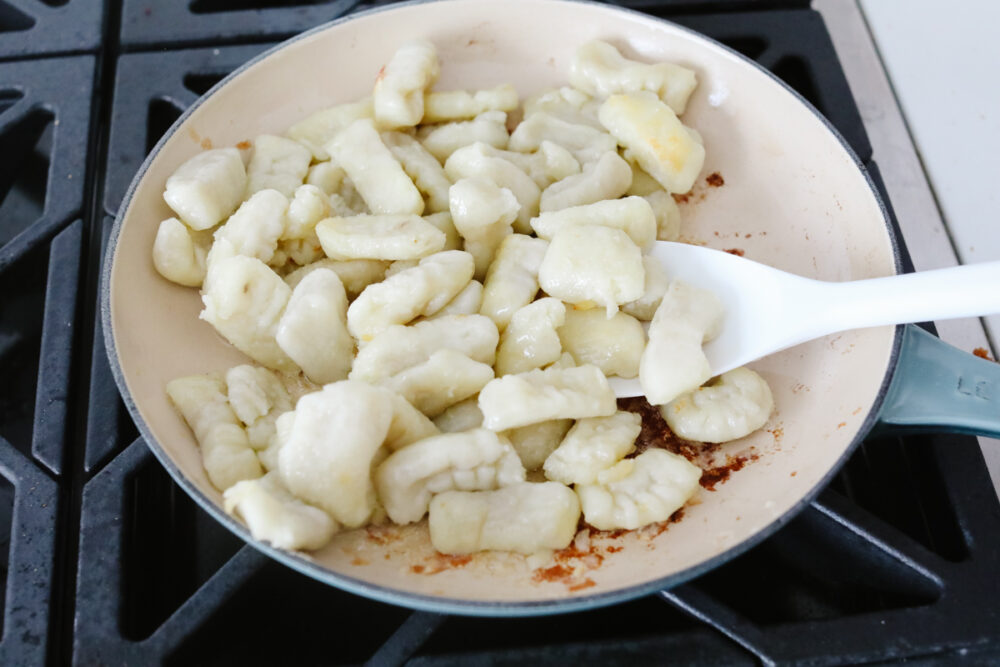 Gnocchi being fried in a pan. 