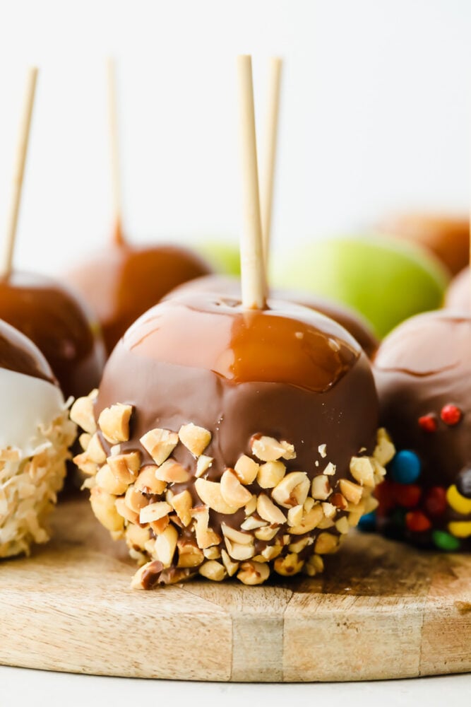 Caramel apples topped with nuts and candies.