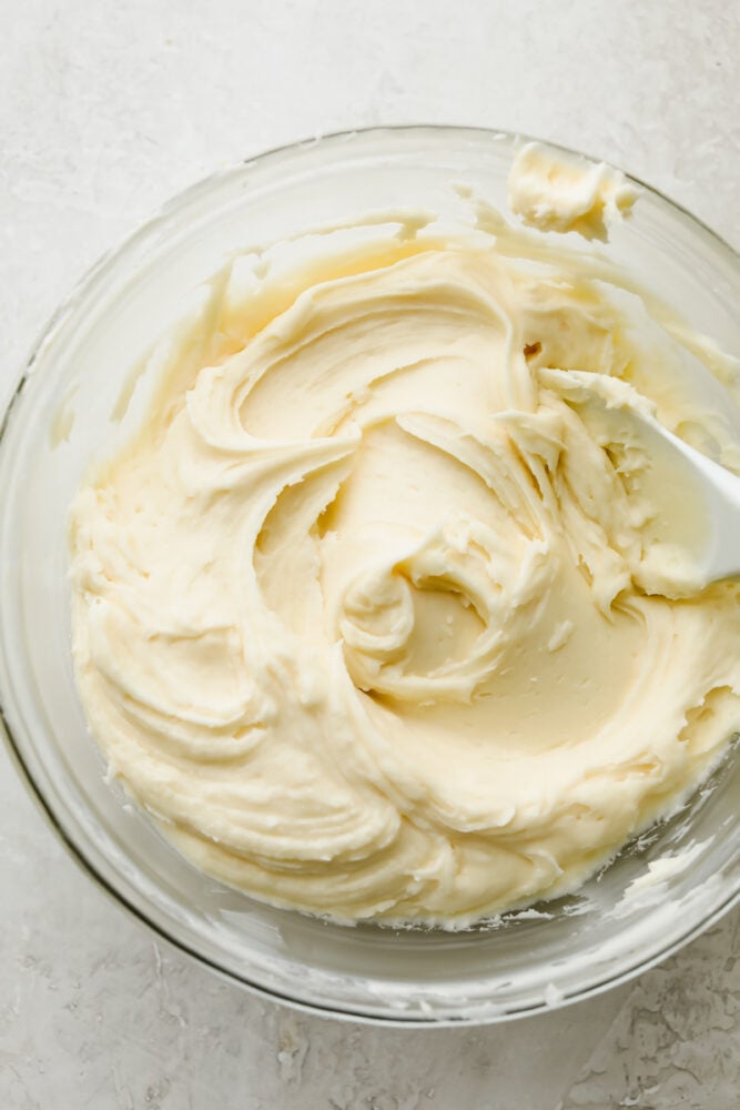 Cream cheese frosting in a bowl with a spoon. 