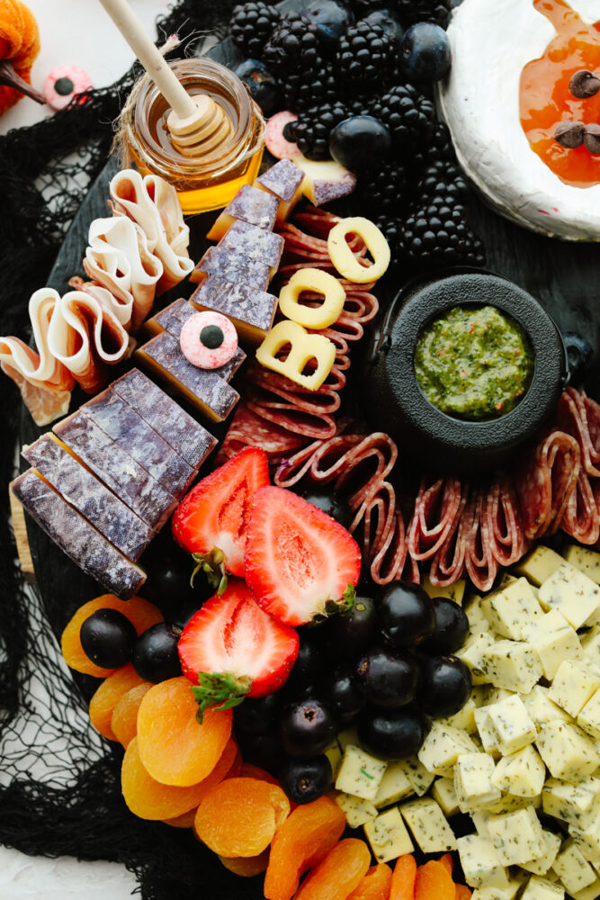 A charcuterie board with fruit being added. 