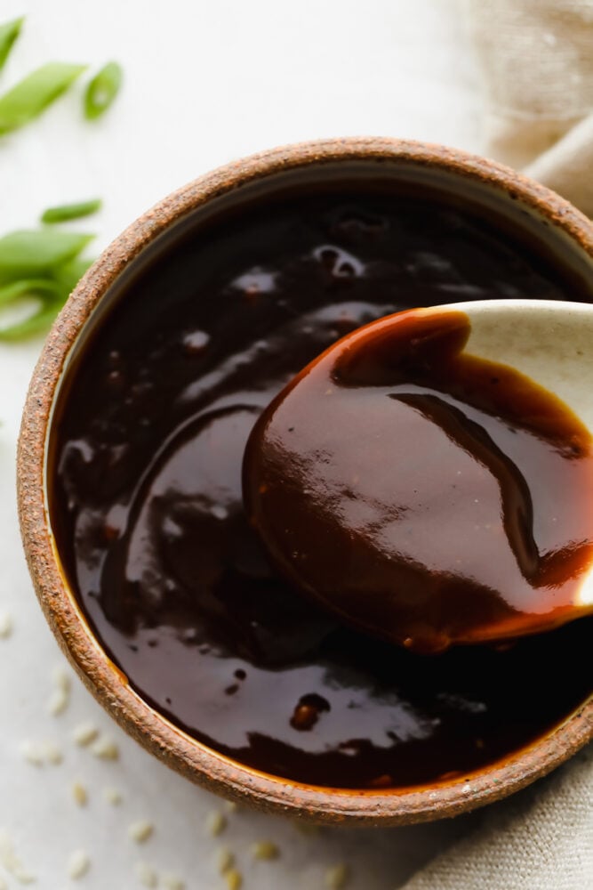 Close-up of a spoon in hoisin sauce.