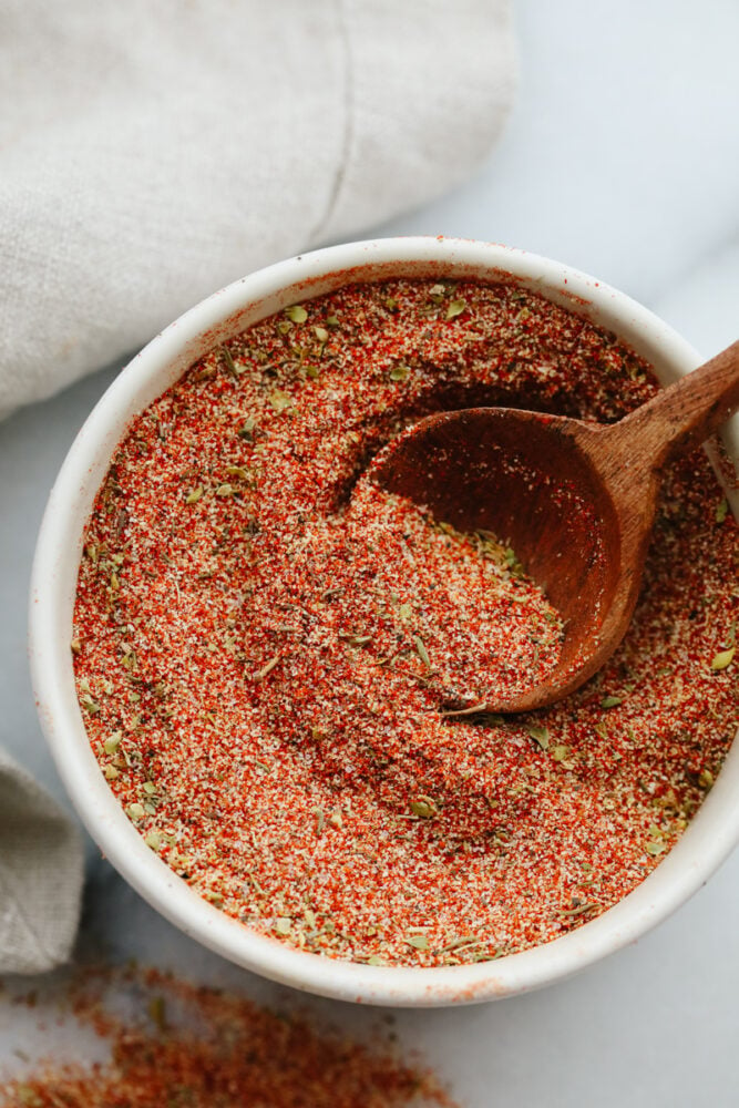 Cajun seasoning with a spoon. 