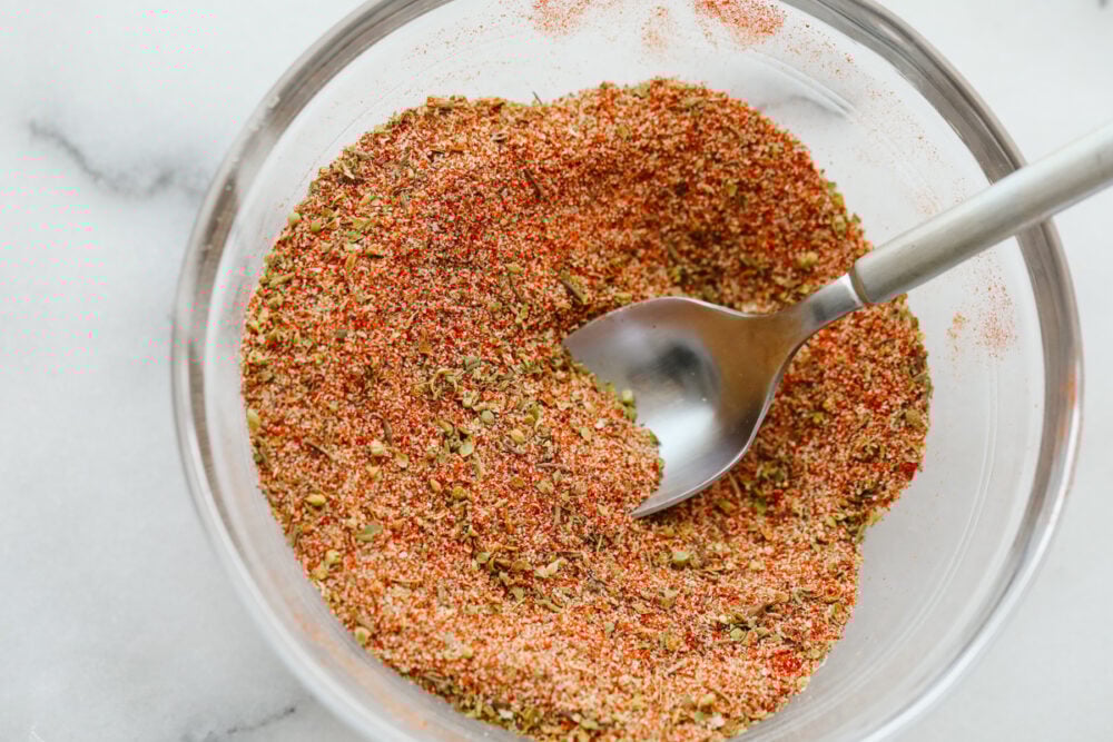 Cajun seasoning is the perfect blend of spices to add a little zest to your dish. Completely versatile and delicious, this homemade spice can be added to a wide variety of recipes giving them just the yummy kick you were looking for! Cajon seasoning mixed in a bowl with a spoon.