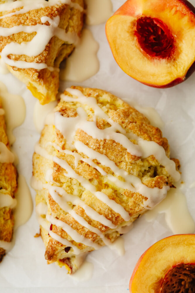Up close picture of a peach scone with vanilla icing. 