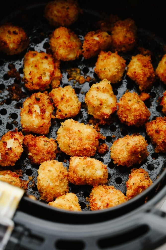 Chicken nuggets cooking in an air fryer.