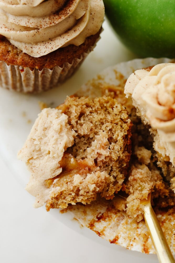 An apple pie cupcake being cut into with a fork. 