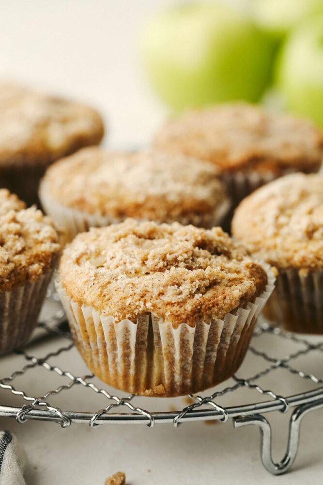 Apple streusel muffins on a wire rack.