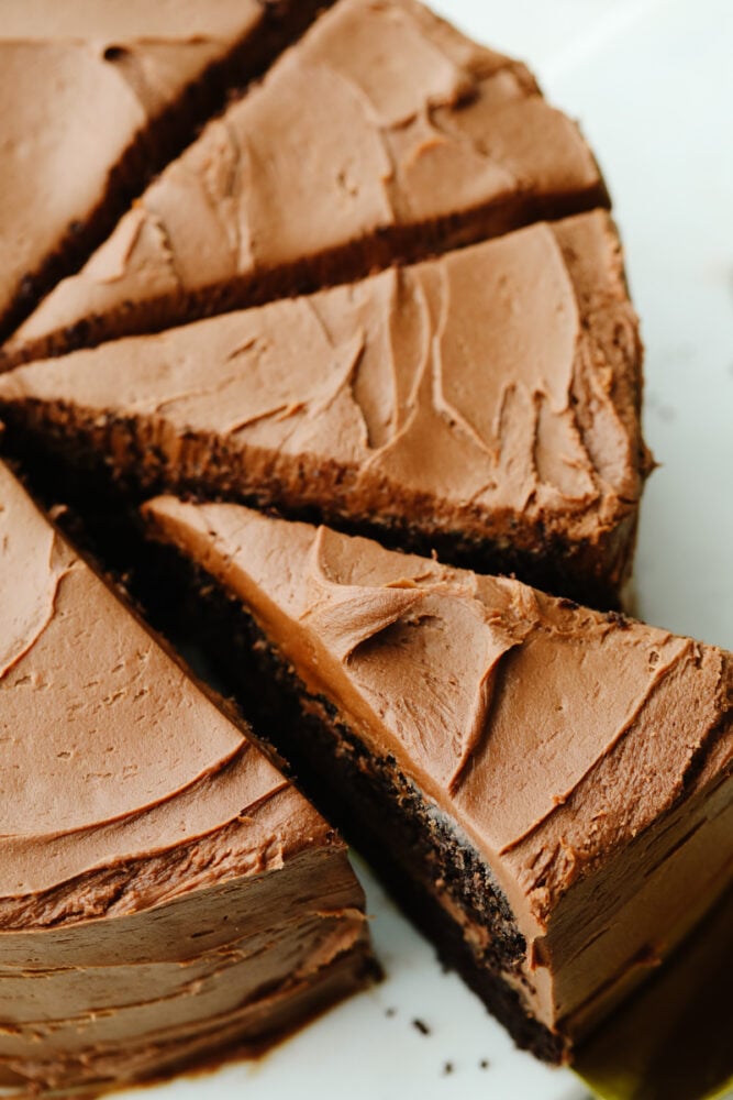 A whole chocolate cake that has been sliced. 