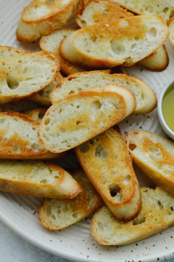 Closeup of crostini pieces on a white plate.