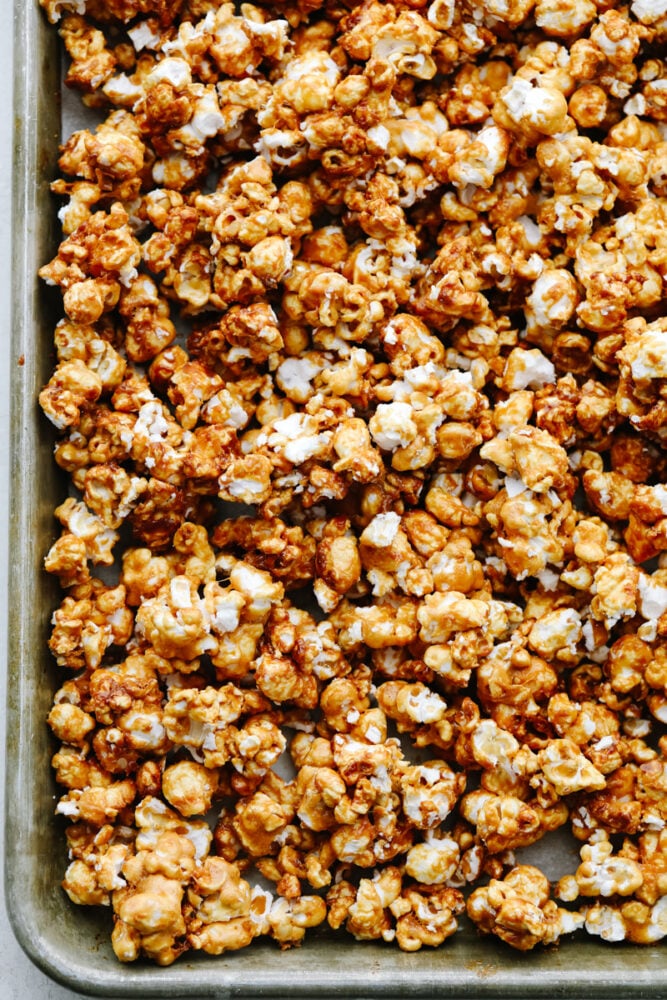 Caramel corn on a baking sheet that is cooked and crunchy. 