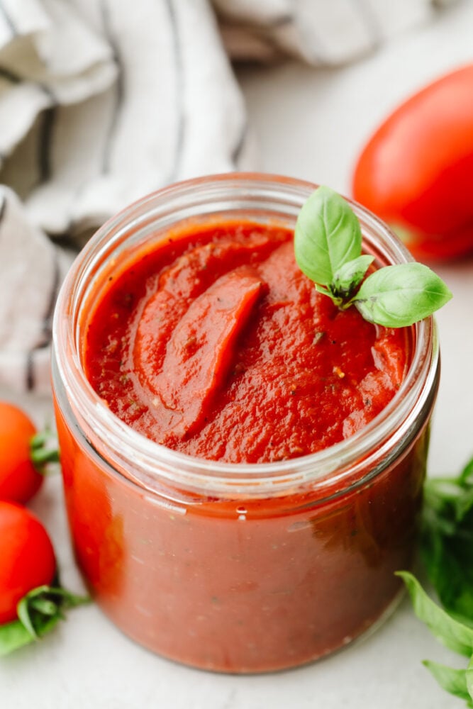 A jar of homemade pizza sauce with 