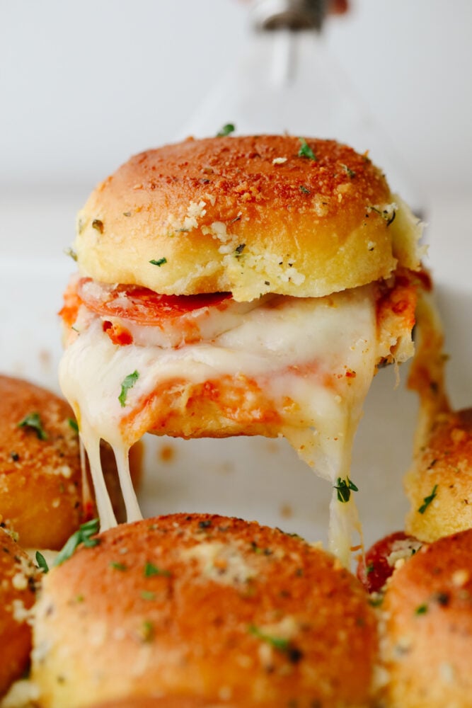 Closeup of pulling a pizza slider out of the pan.