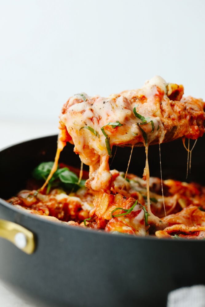 Skillet lasagna being served up with a large spoon. 