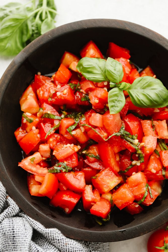 Tomato basil salad in a brown bowl.