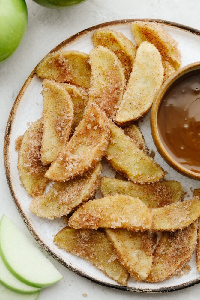A plate of apple fries with caramel dip.