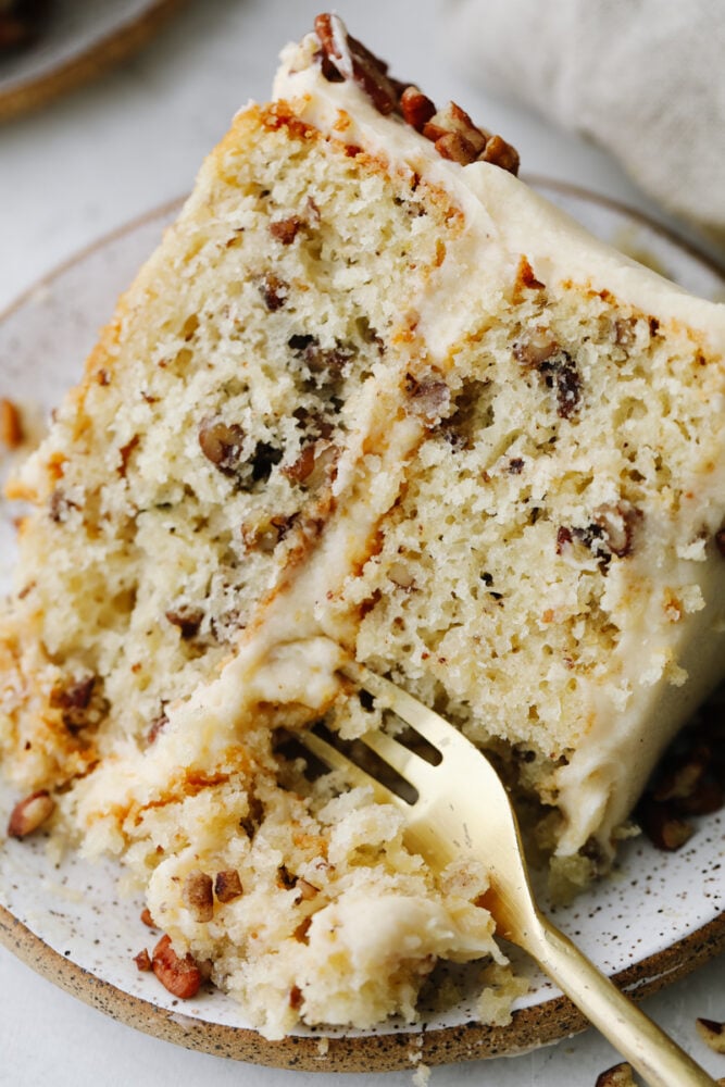 Taking a bite of a slice of butter pecan cake.