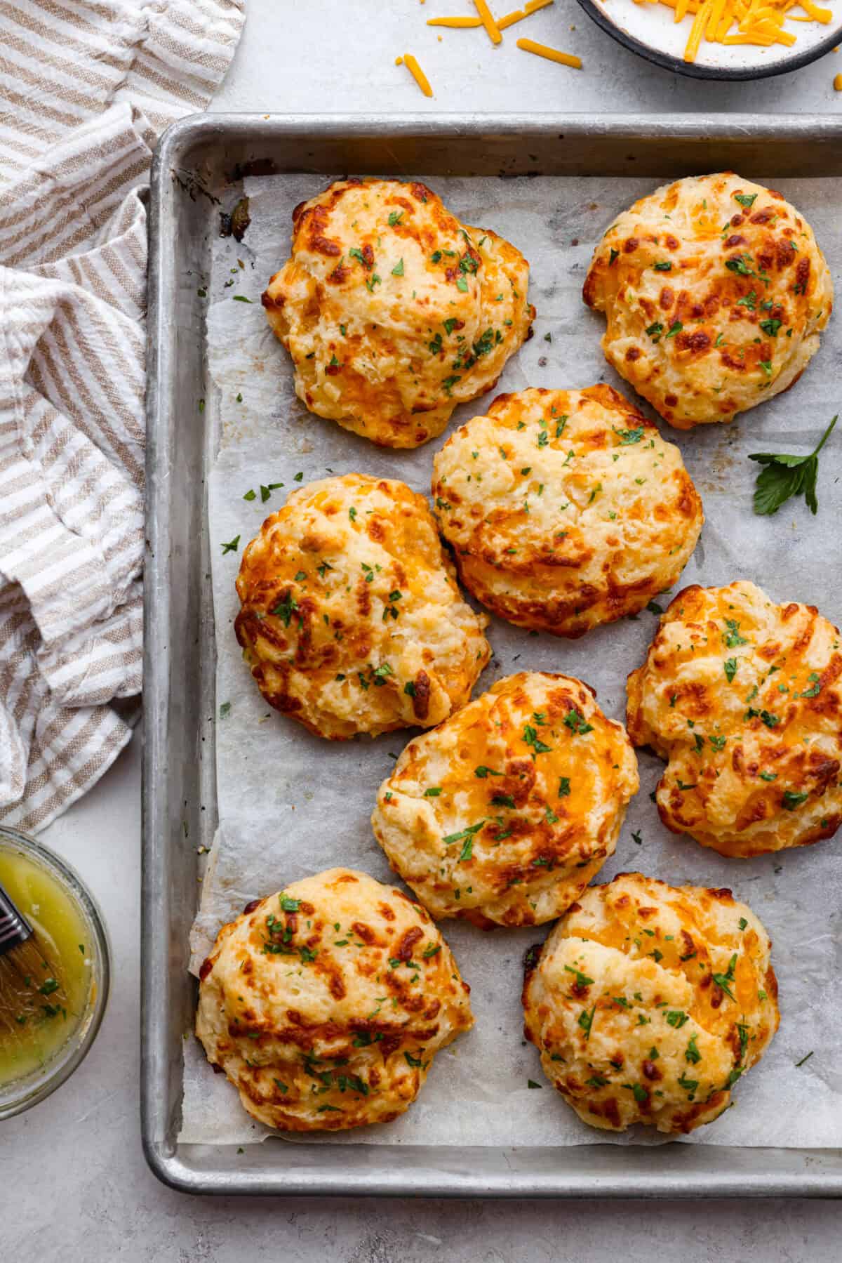 Top view of red lobster cheddar bay biscuits on a baking sheet.