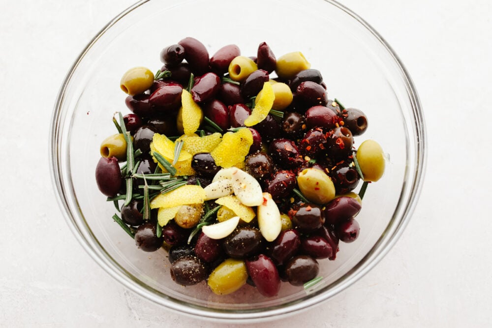 A mix of olives topped with seasonings.