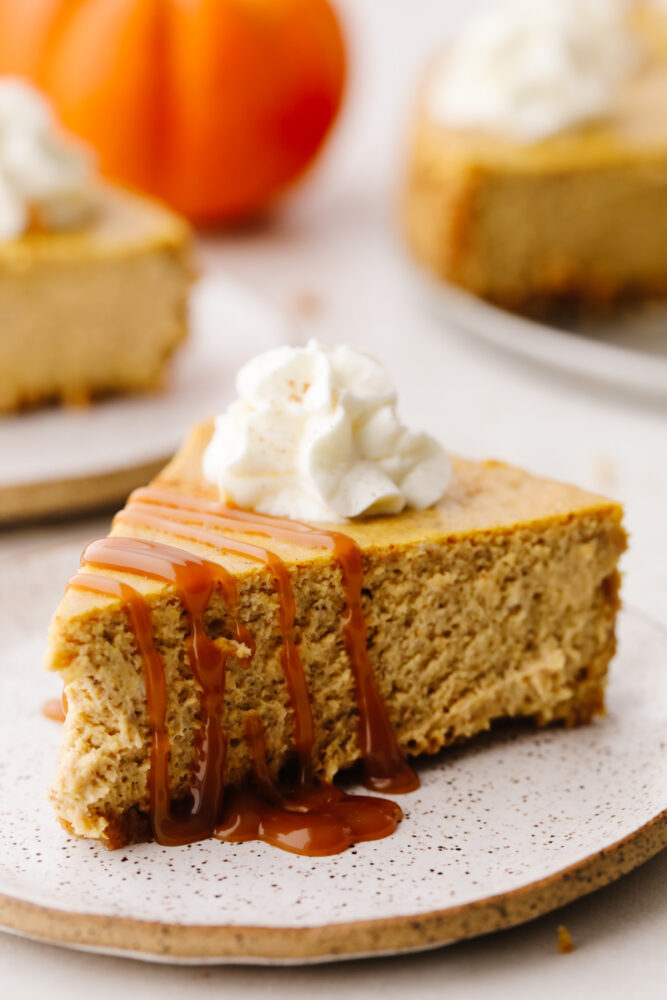A slice of pumpkin cheesecake drizzled with a homemade caramel sauce. 