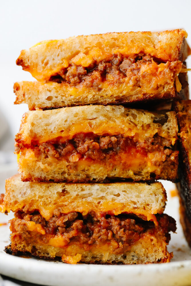 A stack of sliced sloppy joe grilled cheese sandwiches. 