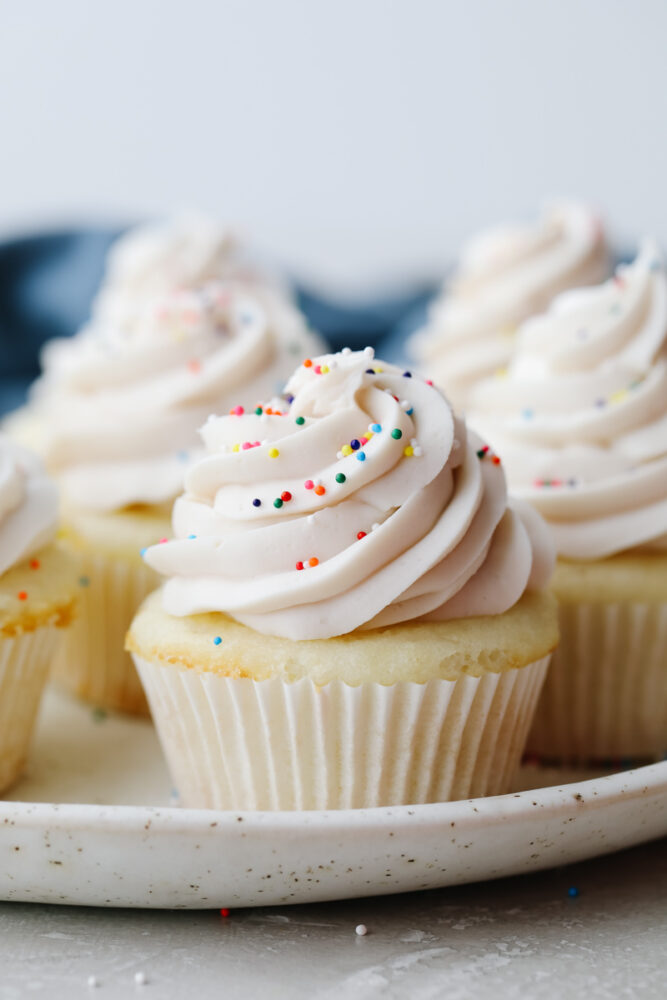 White cupcakes with frosting and sprinkles. 