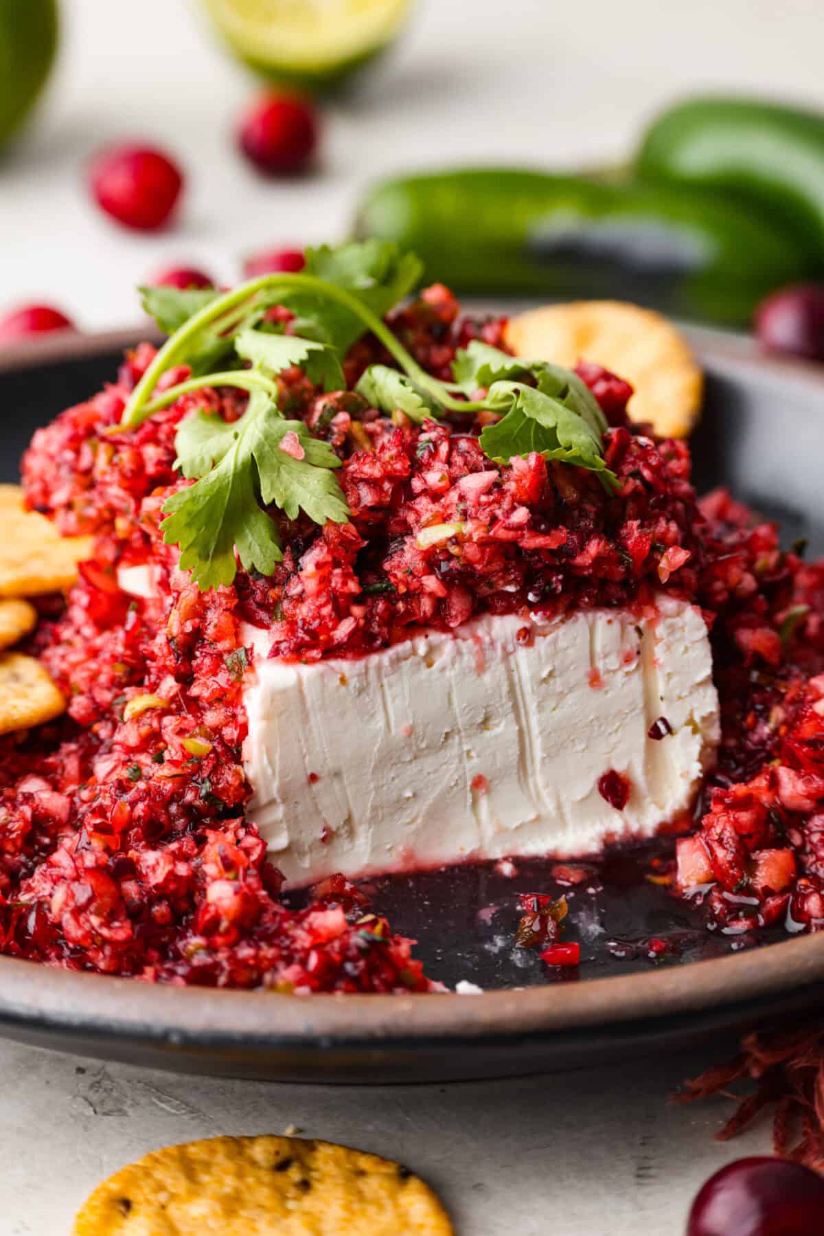 Close up shot of cranberry salsa over cream cheese on a serving platter. 