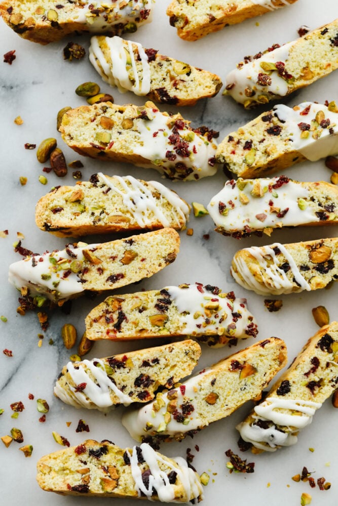 Biscotti pieces laid out, sprinkled with cranberry and pistachio topping.